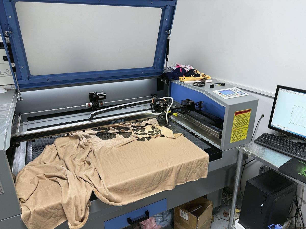 Laser cutter cutting fabric pattern pieces in our workshop